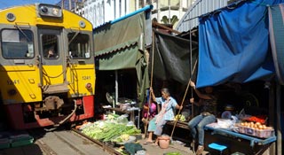 Nice local market with a train rolling through it!